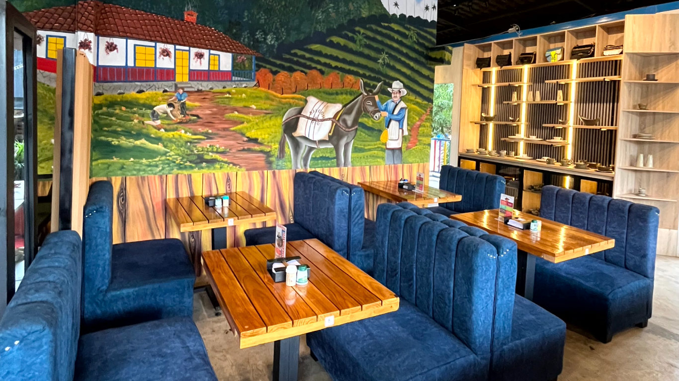 Salón interior con mesas y murales típicos antioqueños